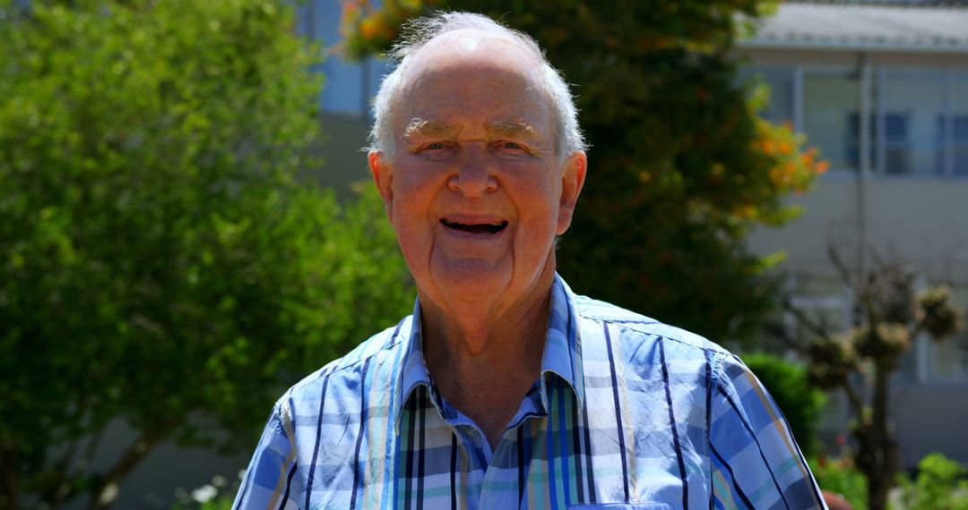Cheerful Senior Man Enjoying Sunny Garden