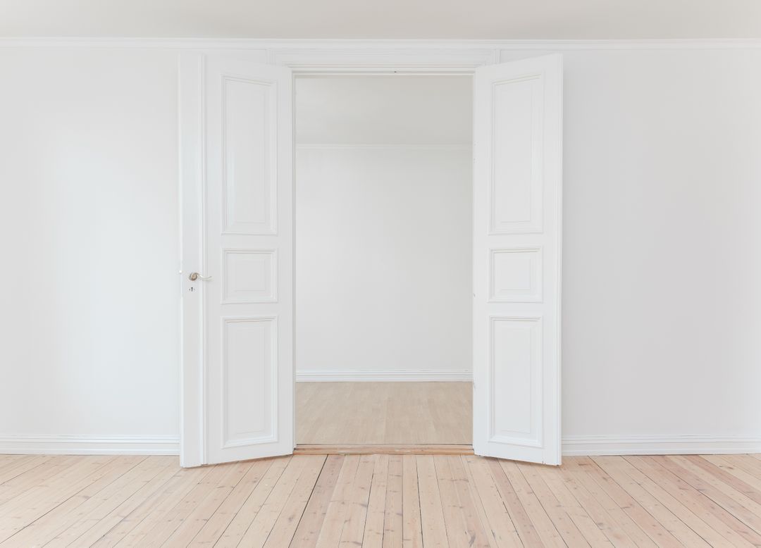 Minimalist Empty Room with White Double Doors and Wooden Floor - Free Images, Stock Photos and Pictures on Pikwizard.com