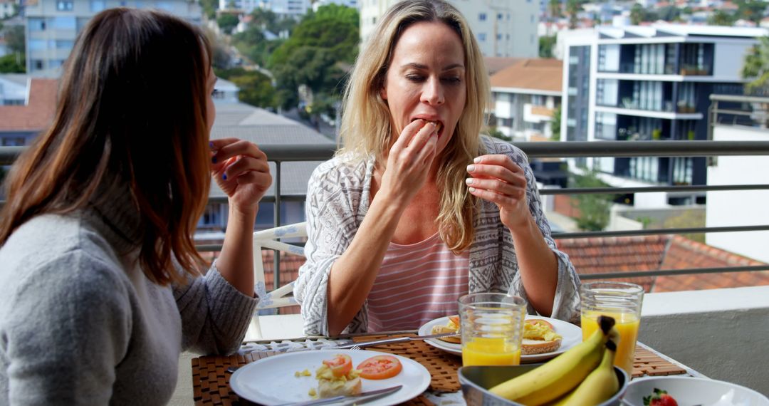 Women Enjoying Breakfast on Balcony in City - Free Images, Stock Photos and Pictures on Pikwizard.com