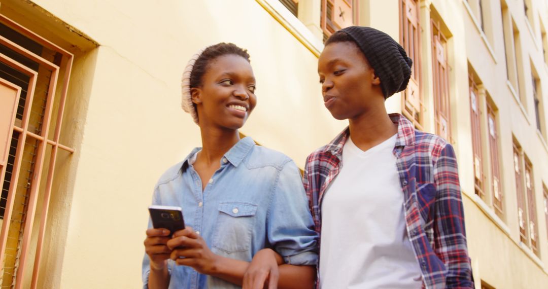 Young Twin Sisters Smiling While Walking in Urban Setting