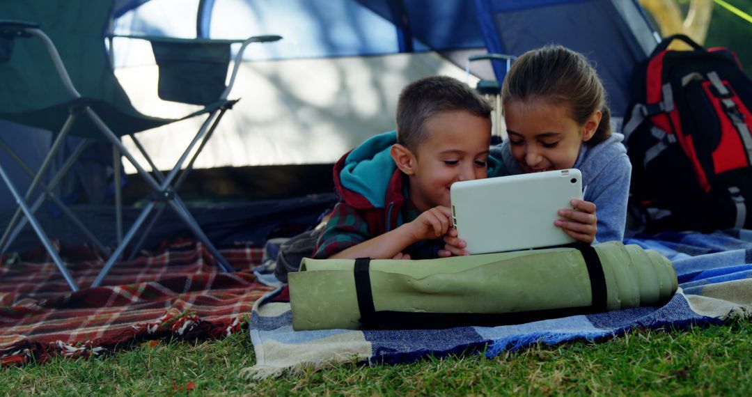 Kids Enjoying Tablet Inside Tent During Camping - Free Images, Stock Photos and Pictures on Pikwizard.com