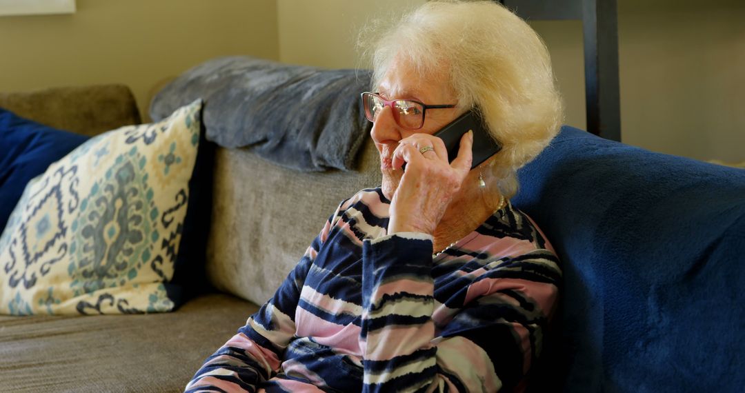 Elderly Woman Sitting on Couch Talking on Smartphone - Free Images, Stock Photos and Pictures on Pikwizard.com