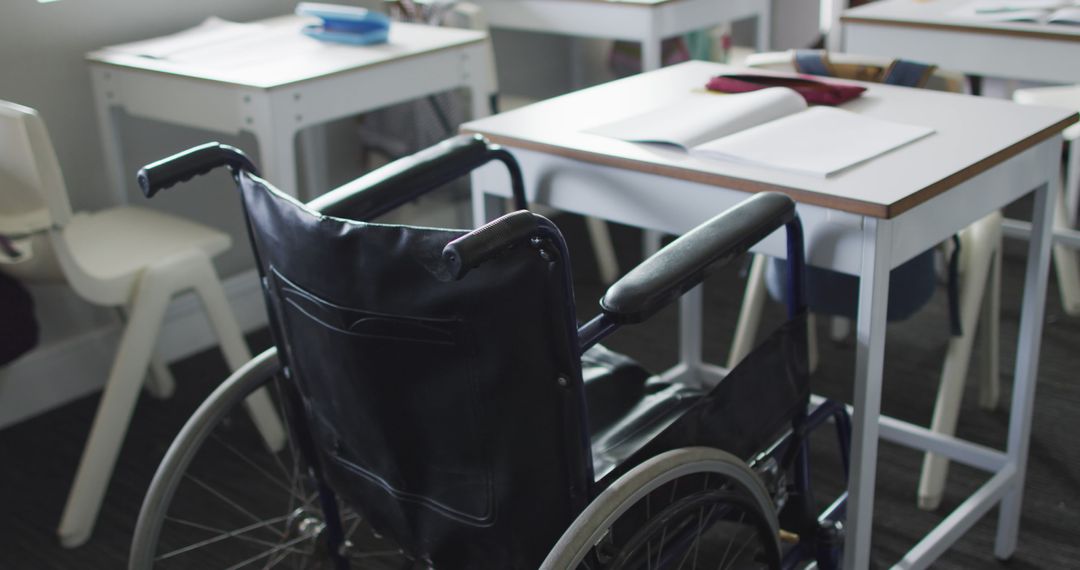 Image of empty wheelchair standing at desk in classroom - Free Images, Stock Photos and Pictures on Pikwizard.com
