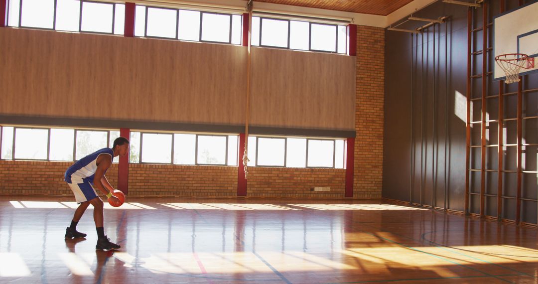 Basketball Player Practicing in Gymnasium with Natural Light - Free Images, Stock Photos and Pictures on Pikwizard.com