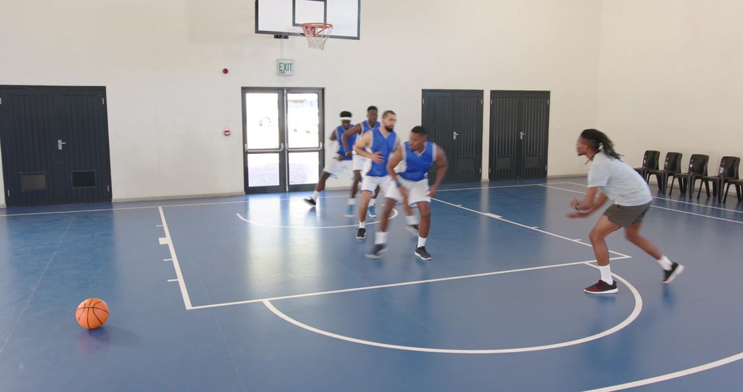 Diverse Male Athletes Practicing Basketball in Gym