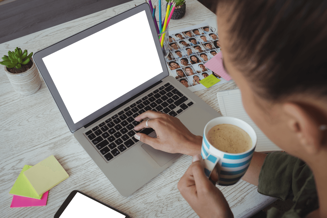 Photo Editor Holding Coffee Making Selections on Laptop Screen