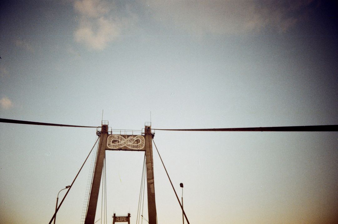 Suspension Bridge with Infinity Symbol at Sunset Against Clear Sky - Free Images, Stock Photos and Pictures on Pikwizard.com