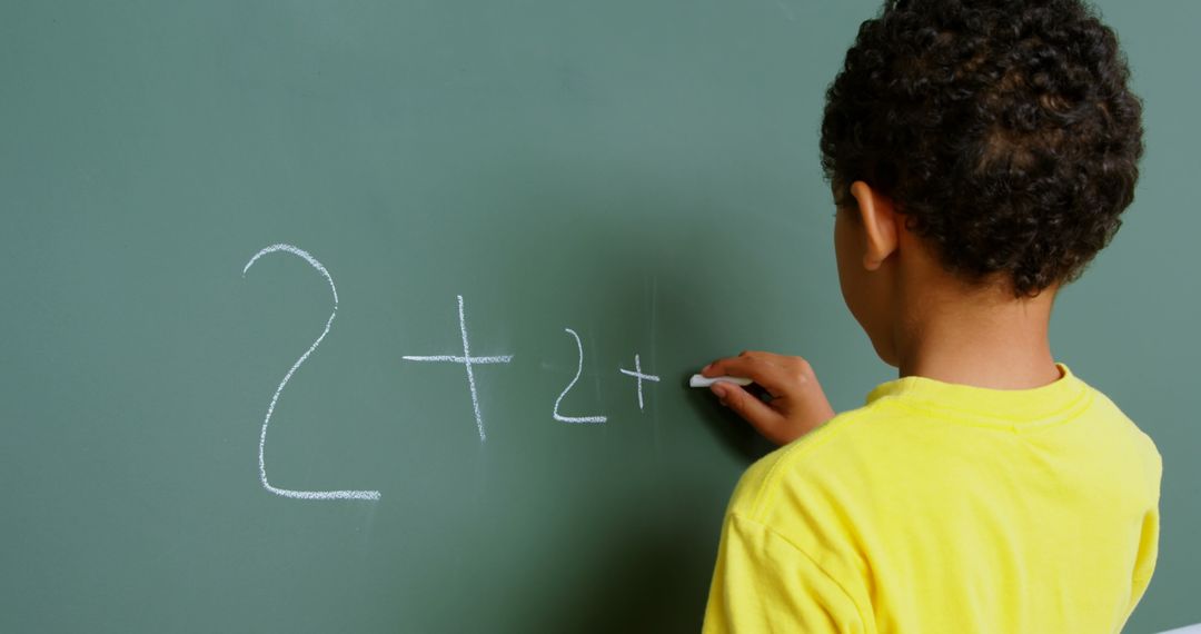 Young Student Solving Math Equation on Chalkboard