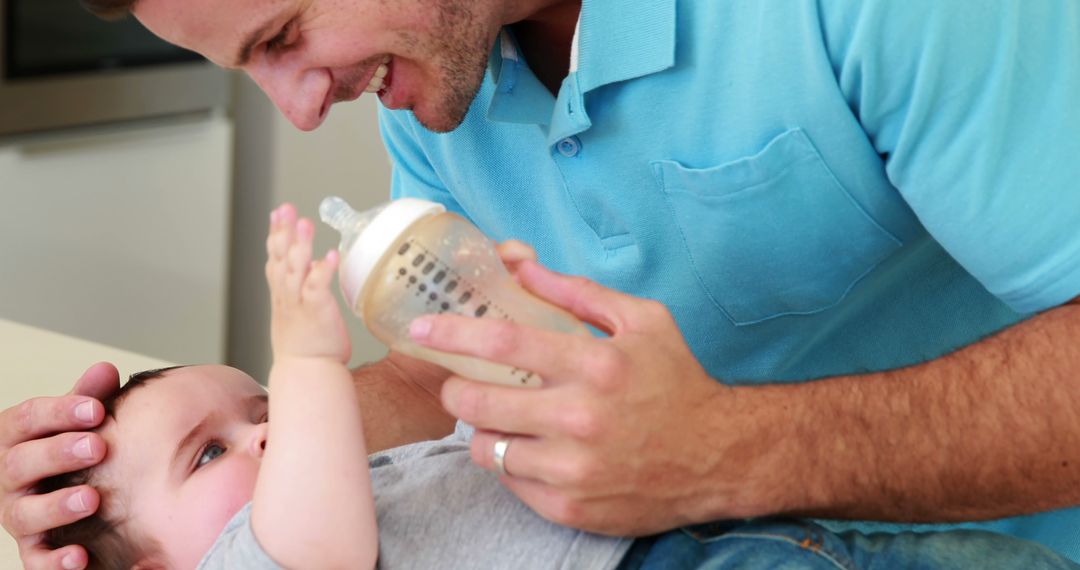 Father Smiling While Feeding Baby with Bottle at Home - Free Images, Stock Photos and Pictures on Pikwizard.com