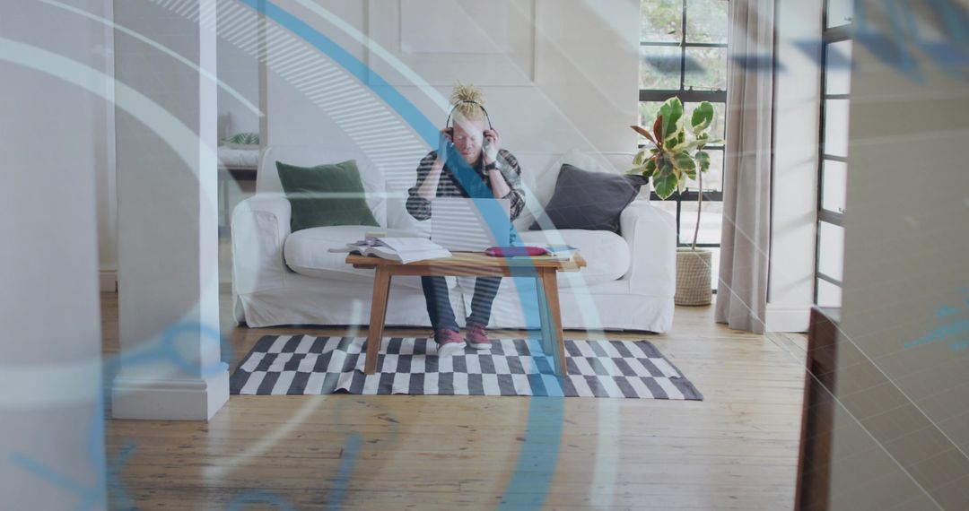 Man Studying in Cozy Living Room with Headphones and Notes