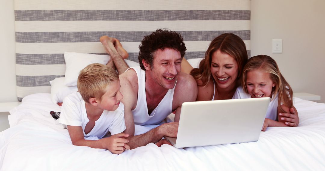 Happy Family Watching Movie on Laptop in Bed Together - Free Images, Stock Photos and Pictures on Pikwizard.com