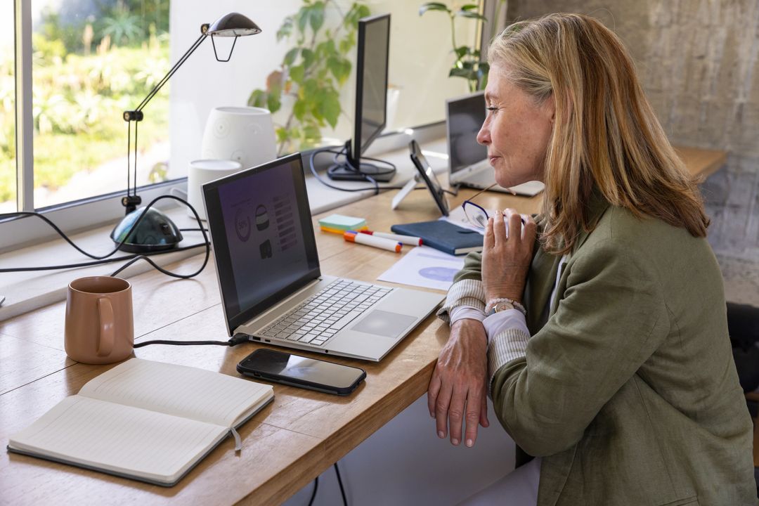 Senior Woman Analyzing Business Charts in Home Office Workspace