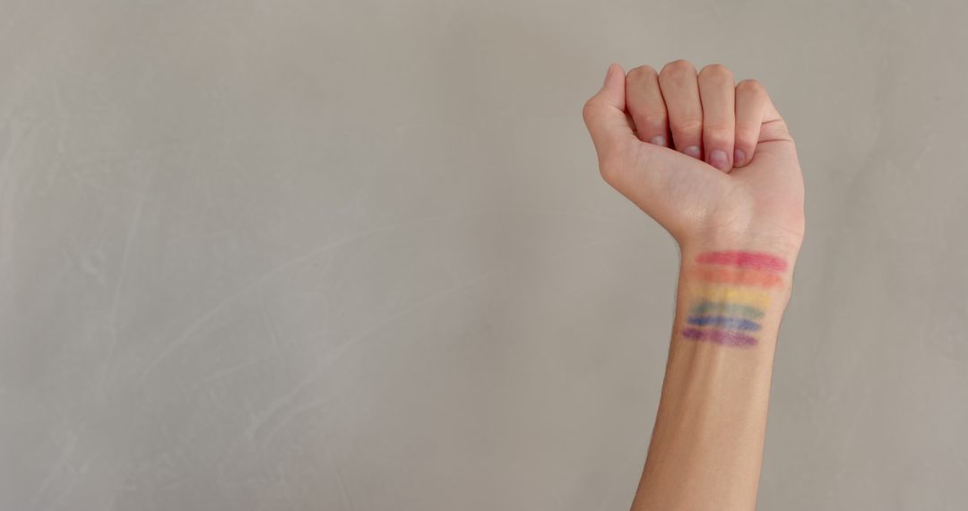 Person Showing Rainbow Stripes on Inner Wrist Against Light Background
