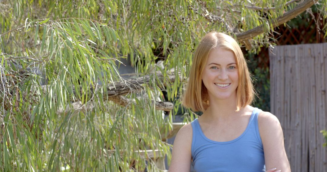 Young Woman Relaxing in Serene Backyard Garden with Willow Tree
