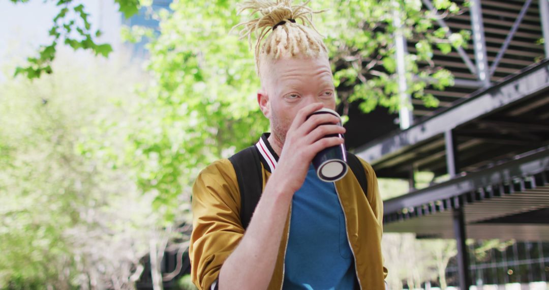 Young Man with Dreadlocks Drinking Coffee Outdoors on Sunny Day - Free Images, Stock Photos and Pictures on Pikwizard.com