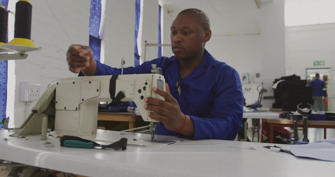 Man Operating Industrial Sewing Machine in Textile Workshop