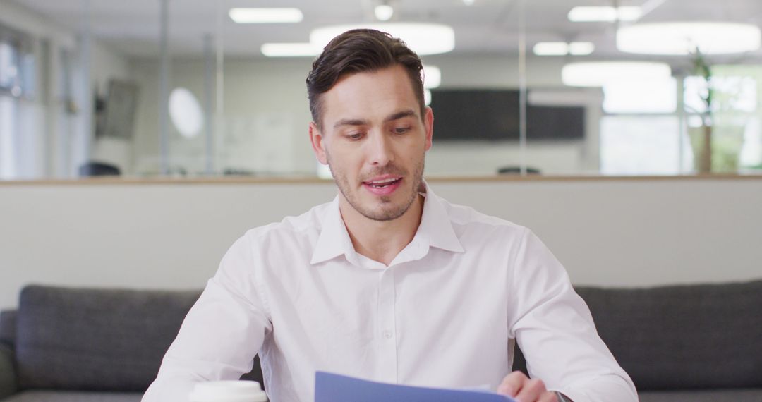 Caucasian Businessman Engaging in Video Call at Modern Office