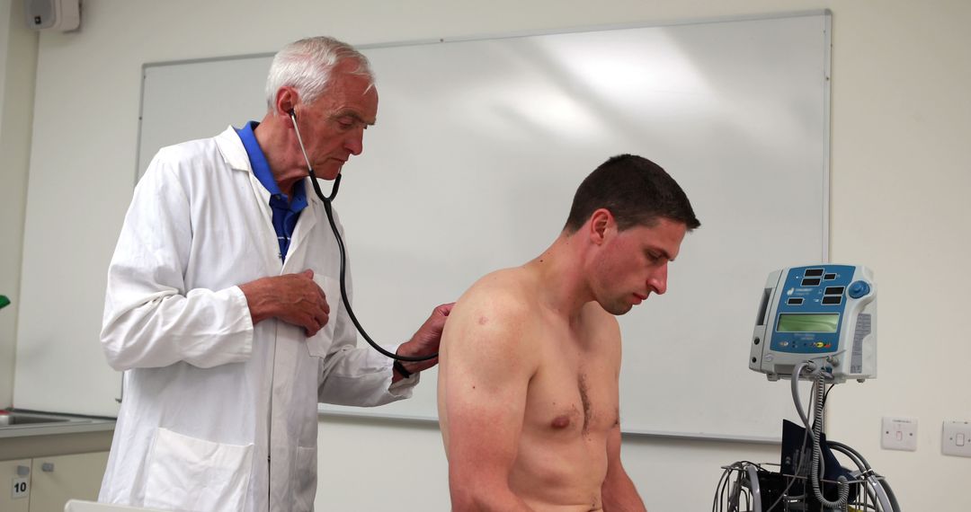 Older Doctor Performing Medical Examination with Stethoscope on Male Patient - Free Images, Stock Photos and Pictures on Pikwizard.com