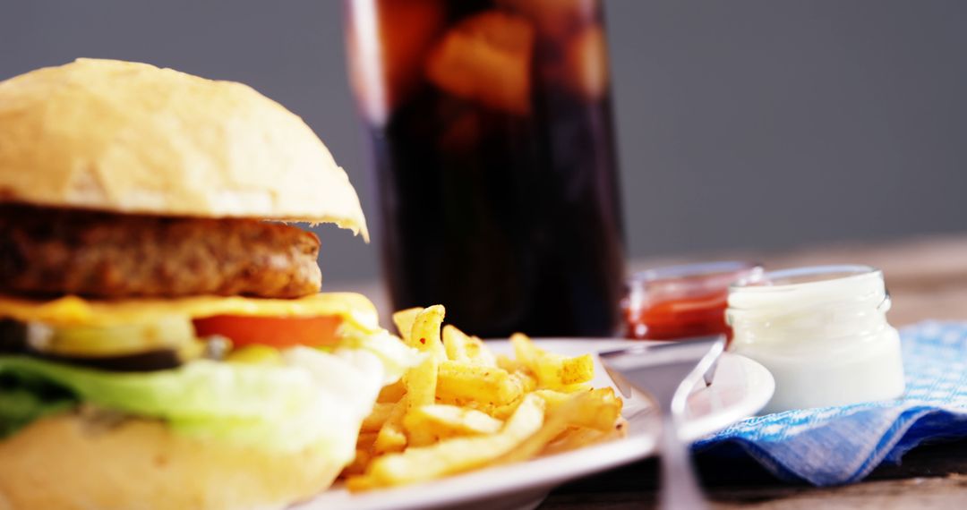 Close-up of Delicious Burger and Fries with Soda in Background - Free Images, Stock Photos and Pictures on Pikwizard.com