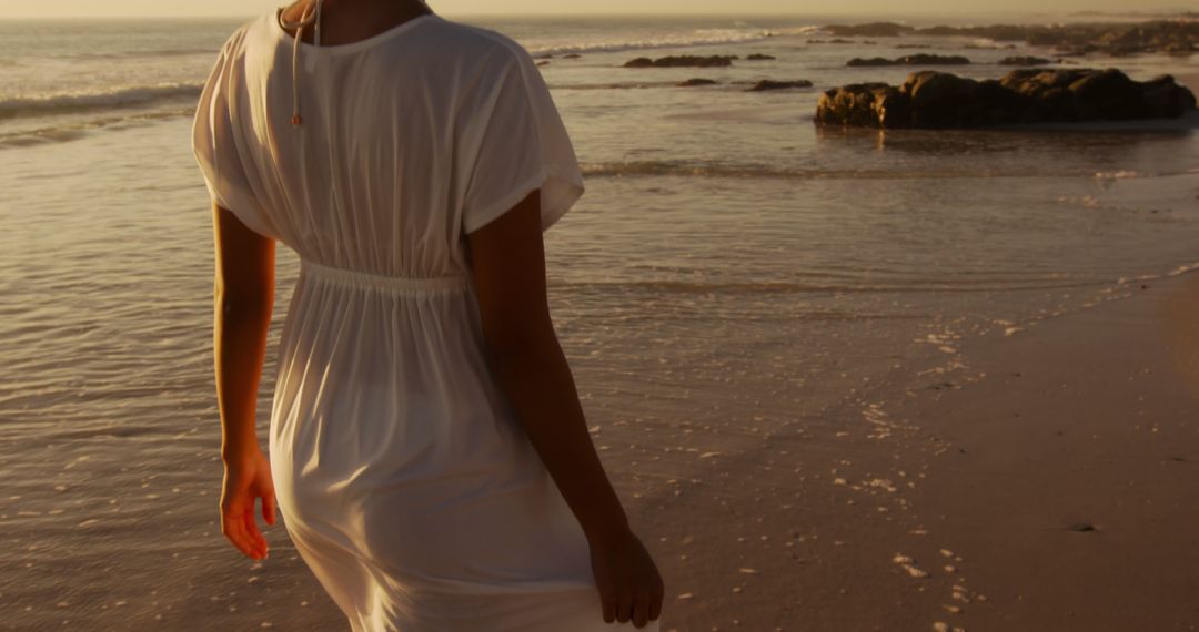 Woman in White Dress Walking on Beach at Sunset - Free Images, Stock Photos and Pictures on Pikwizard.com