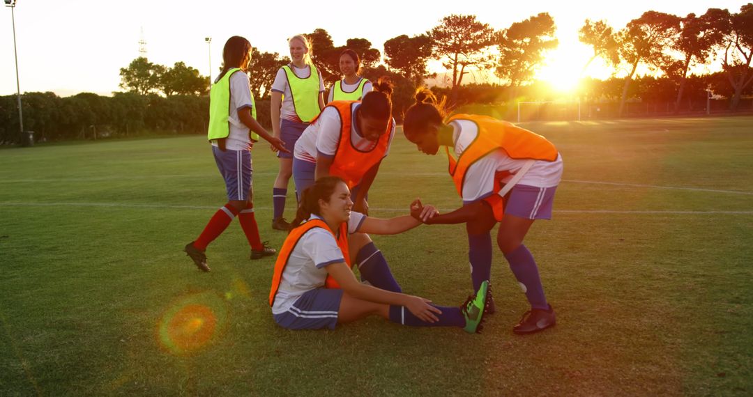 Female Soccer Team Supporting Injured Teammate at Sunset - Free Images, Stock Photos and Pictures on Pikwizard.com