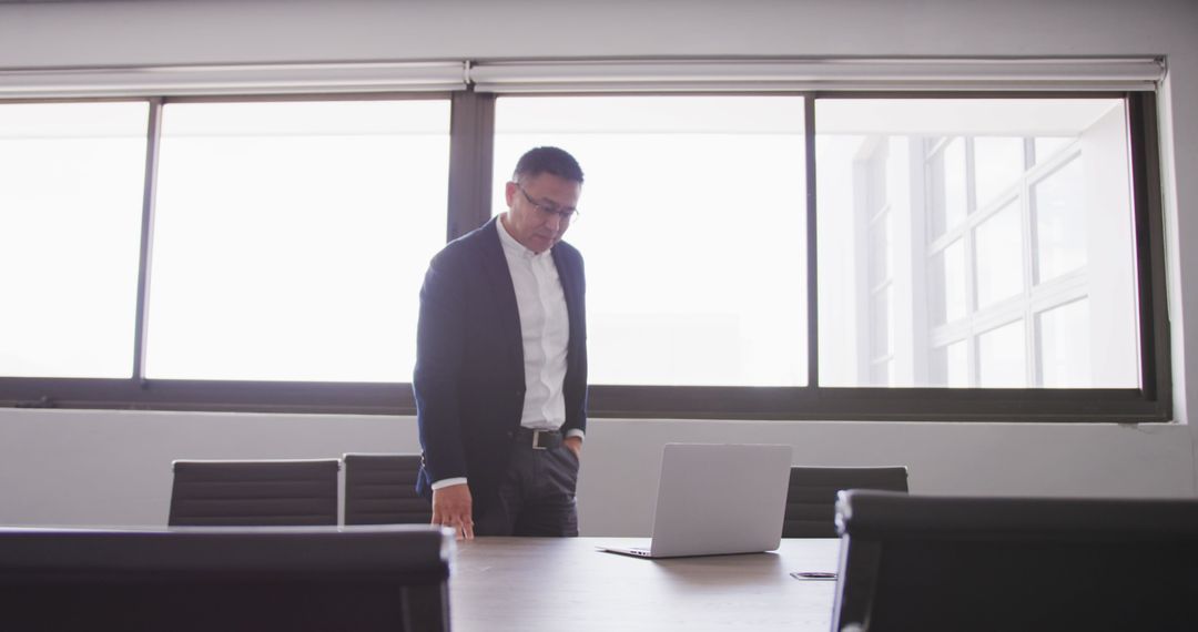 Businessman Engaging With Laptop in Modern Office Environment
