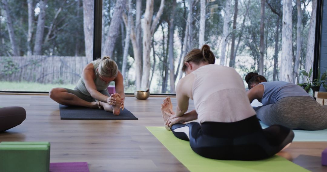 Women Practicing Yoga in Tranquil Studio Environment - Free Images, Stock Photos and Pictures on Pikwizard.com