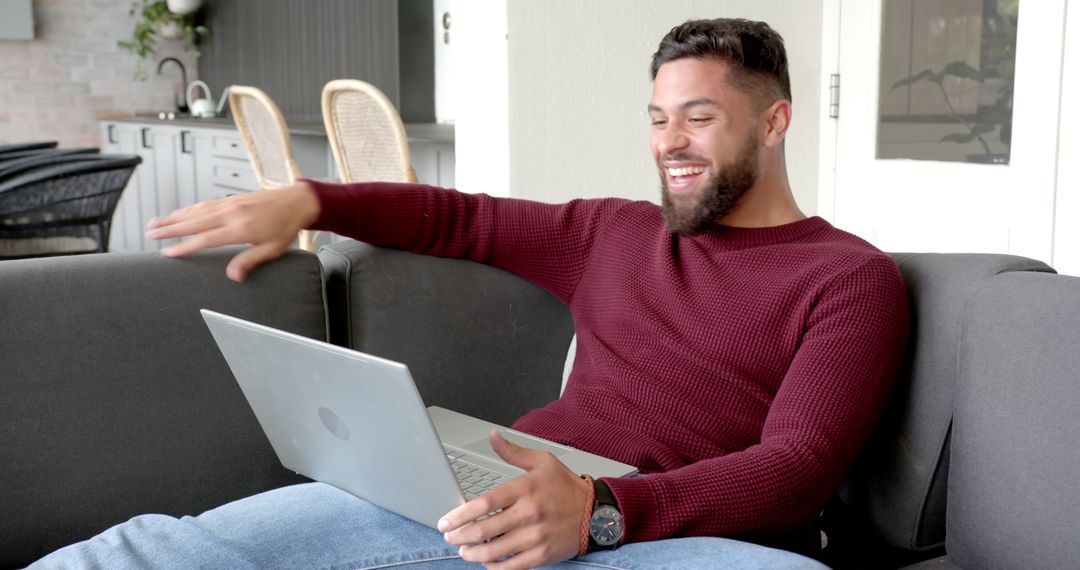 Smiling Bearded Man Using Laptop in Modern Living Room Environment