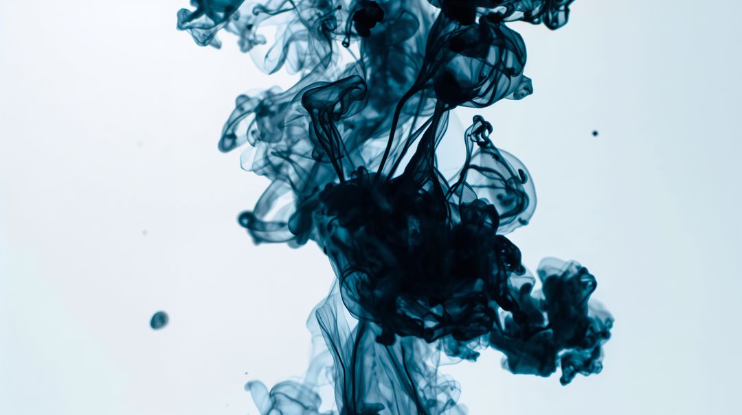 Billowing Teal Indigo Ink Plume Dissolving in Water with Wispy Tendrils and Droplets Macro