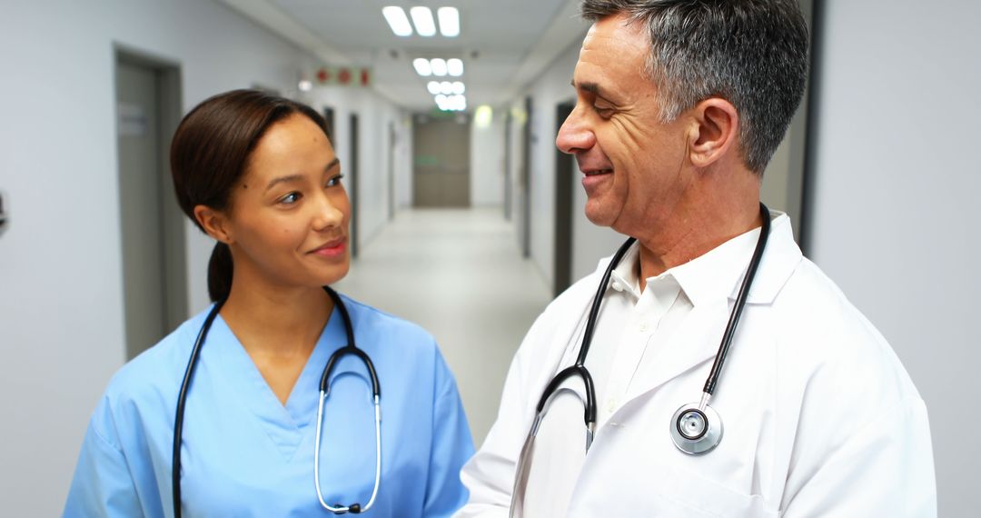 Friendly Doctors Collaborating in Hospital Corridor - Free Images, Stock Photos and Pictures on Pikwizard.com