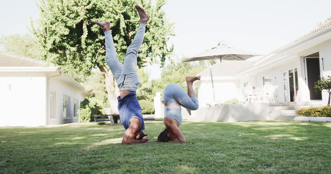 Couple Practicing Yoga Headstands in Backyard on Sunny Day - Free Images, Stock Photos and Pictures on Pikwizard.com