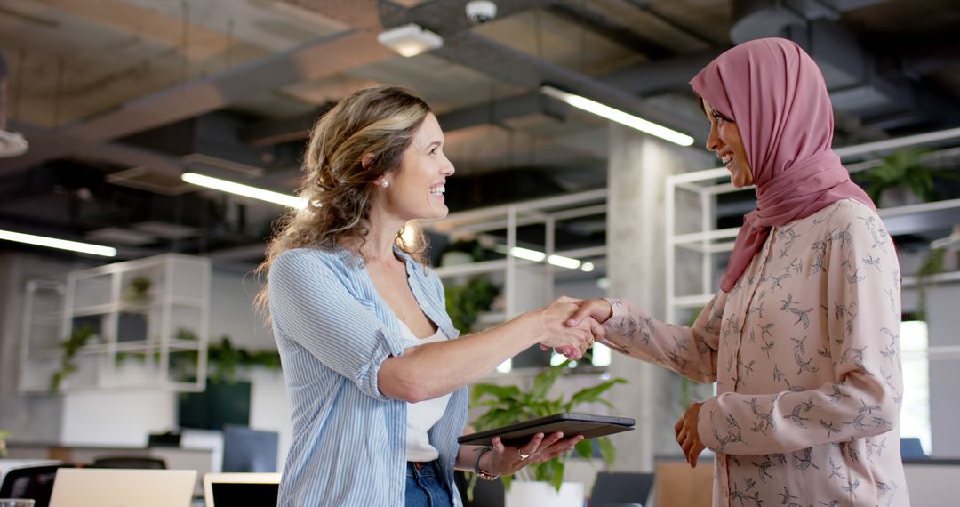 Businesswomen Shaking Hands in Modern Office - Free Images, Stock Photos and Pictures on Pikwizard.com