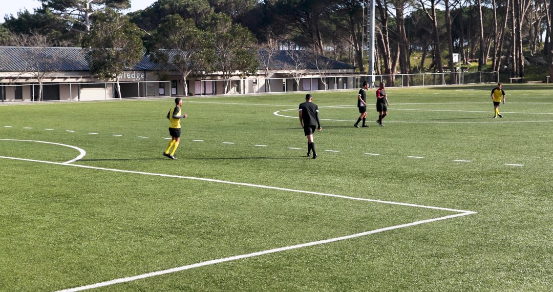 Amateur Soccer Match on Sunny Day with Players Passing Ball