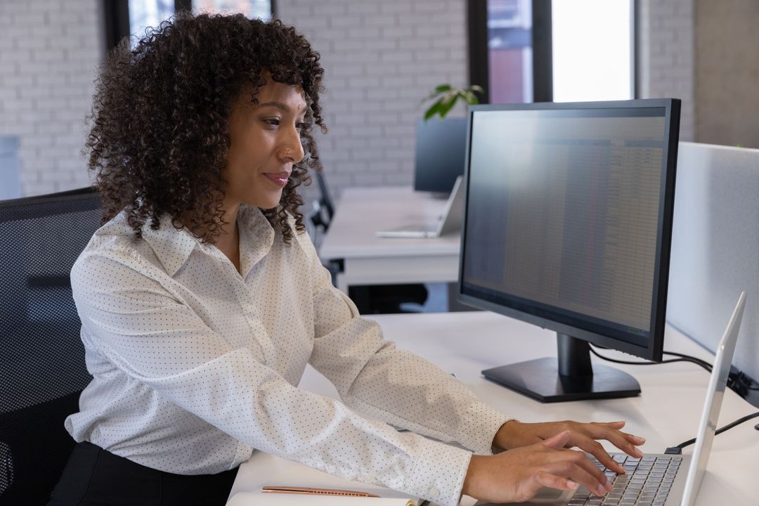 Young Professional Woman Analyzing Data on Computer in Modern Office