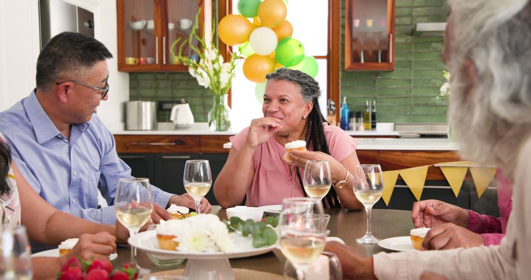 Joyful Seniors Celebrating Around Table with Cupcakes and Wine