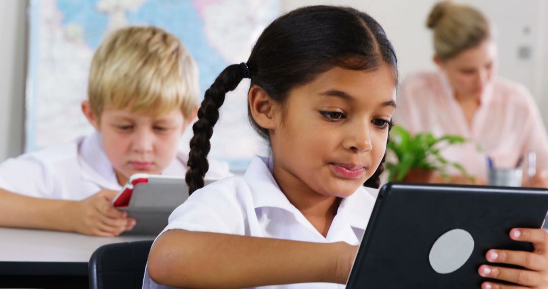 Schoolchildren Engaged in Learning with Digital Tablets in Classroom