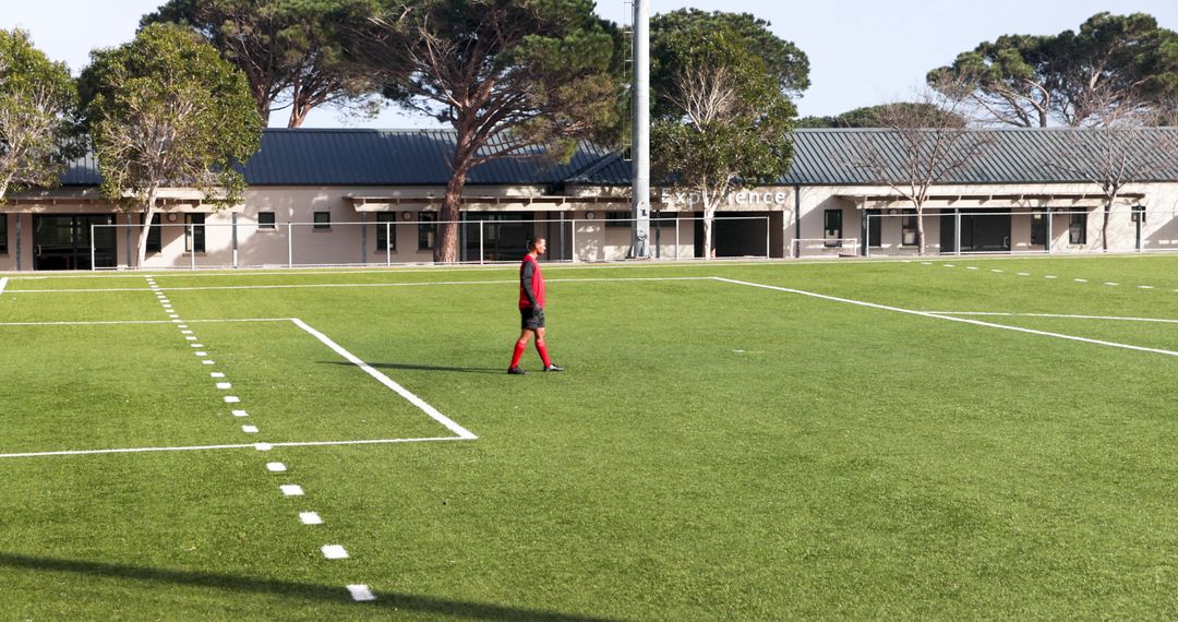 Soccer Player in Red Uniform Standing on Field on Sunny Day