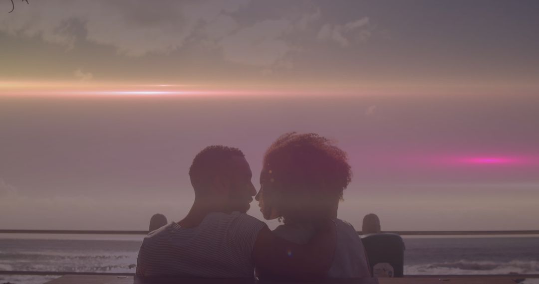 Couple on Beach Embracing at Sunset with Lens Flare