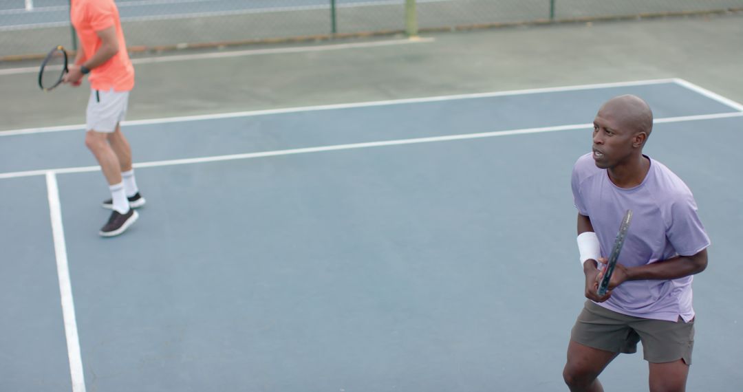 Focused Male Tennis Players on Blue Court - Free Images, Stock Photos and Pictures on Pikwizard.com