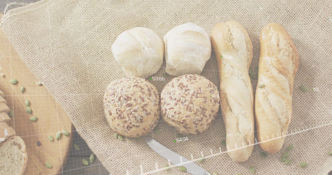 Arranging Rustic Artisan Bread Rolls and Baguettes on Burlap with Serrated Knife