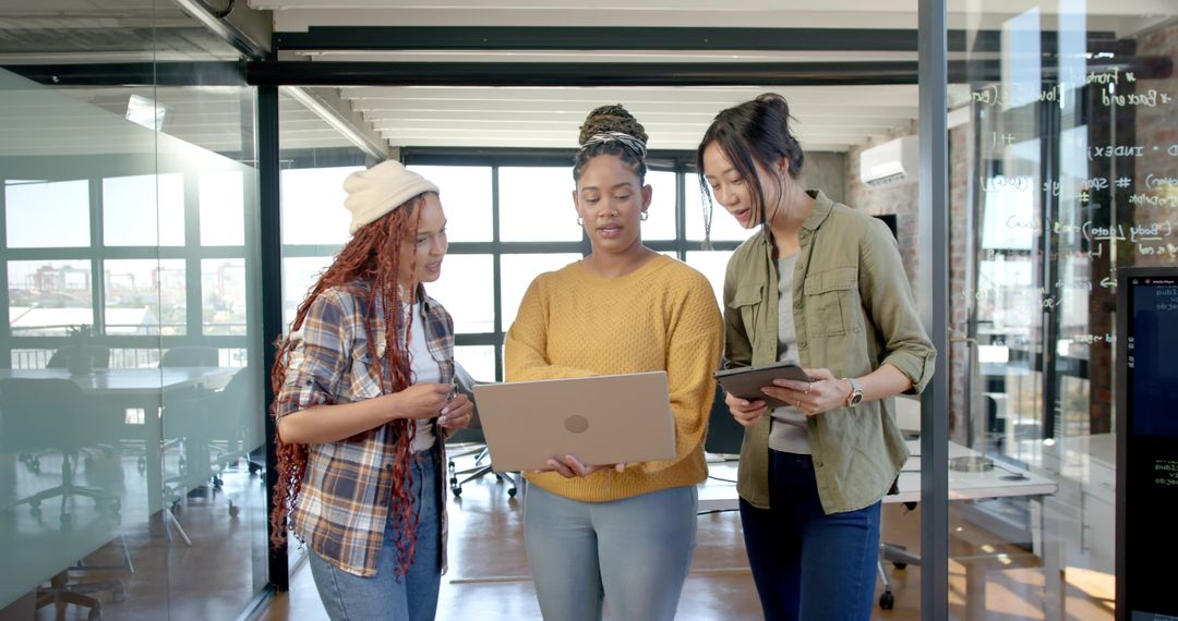 Diverse Female Coworkers Brainstorming Over Laptop and Tablet