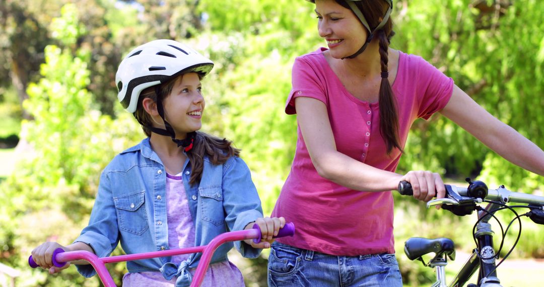 Mother Teaching Daughter to Ride Bike in Sunny Park - Free Images, Stock Photos and Pictures on Pikwizard.com