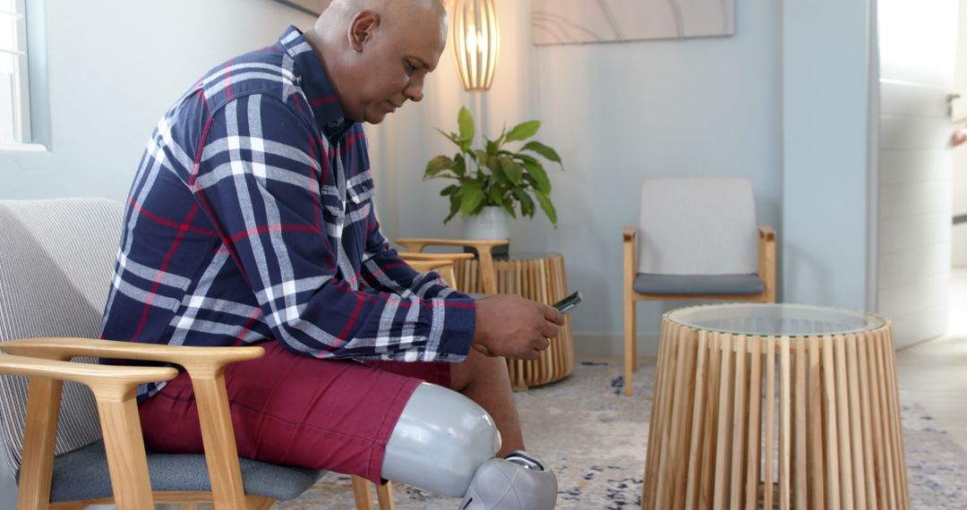 Man with Prosthetic Leg Using Smartphone in Relaxed Setting