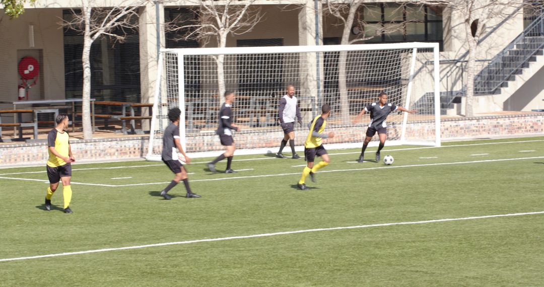 Soccer Players in Intense Match Near Goal on Sunny Day