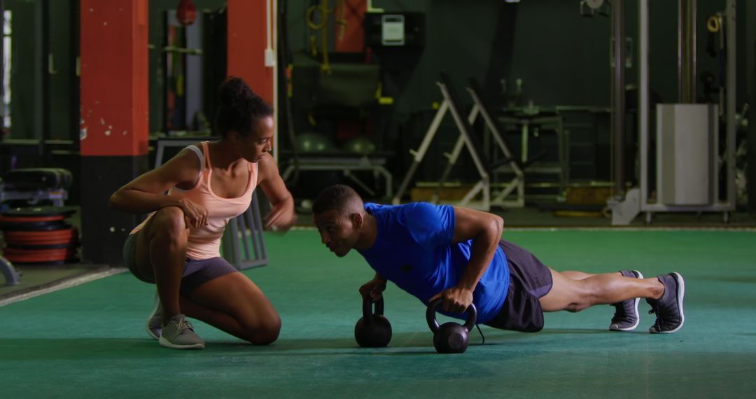 Fitness Trainer Coaching Man Performing Kettlebell Push Ups at Gym Download Free Image from Pikwizard