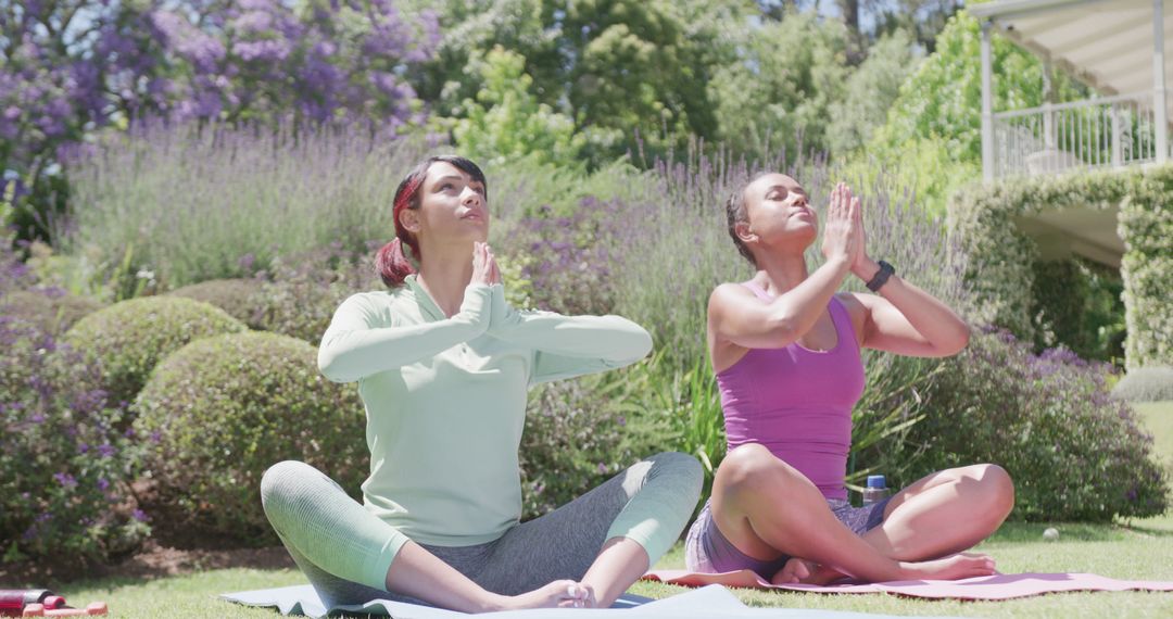 Two Women Practicing Meditation Outdoors in Sunny Garden - Free Images, Stock Photos and Pictures on Pikwizard.com