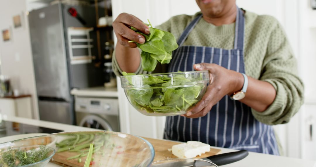 Woman Preparing Fresh Salad with Spinach in Home Kitchen - Free Images, Stock Photos and Pictures on Pikwizard.com