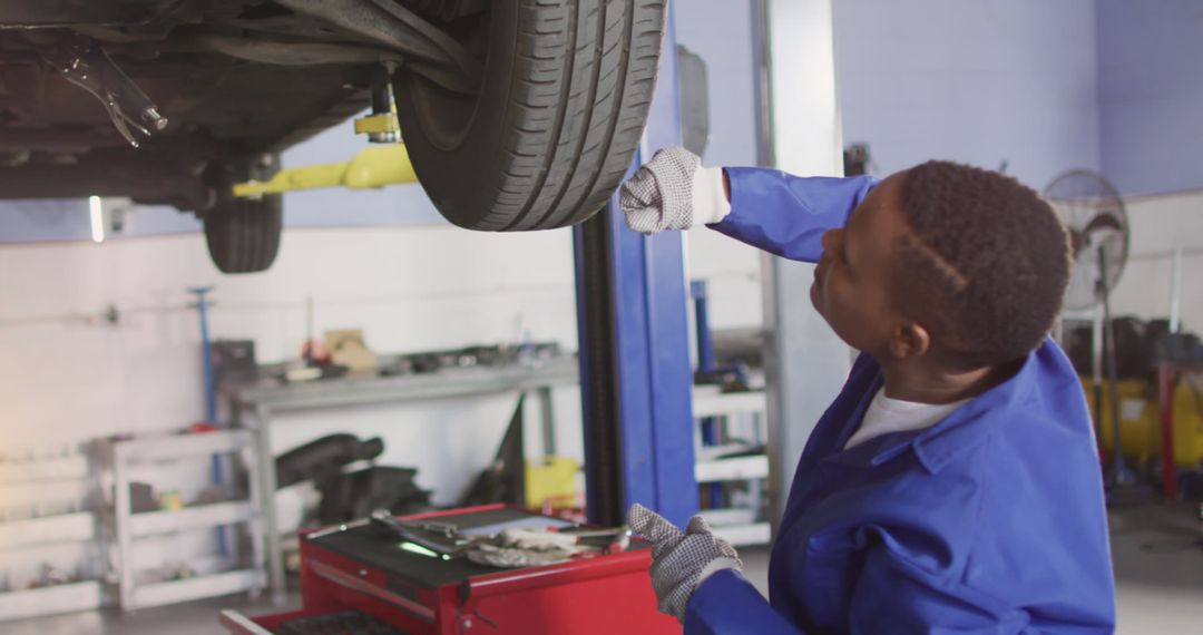 Mechanic Performing Maintenance on Car Tire in Workshop