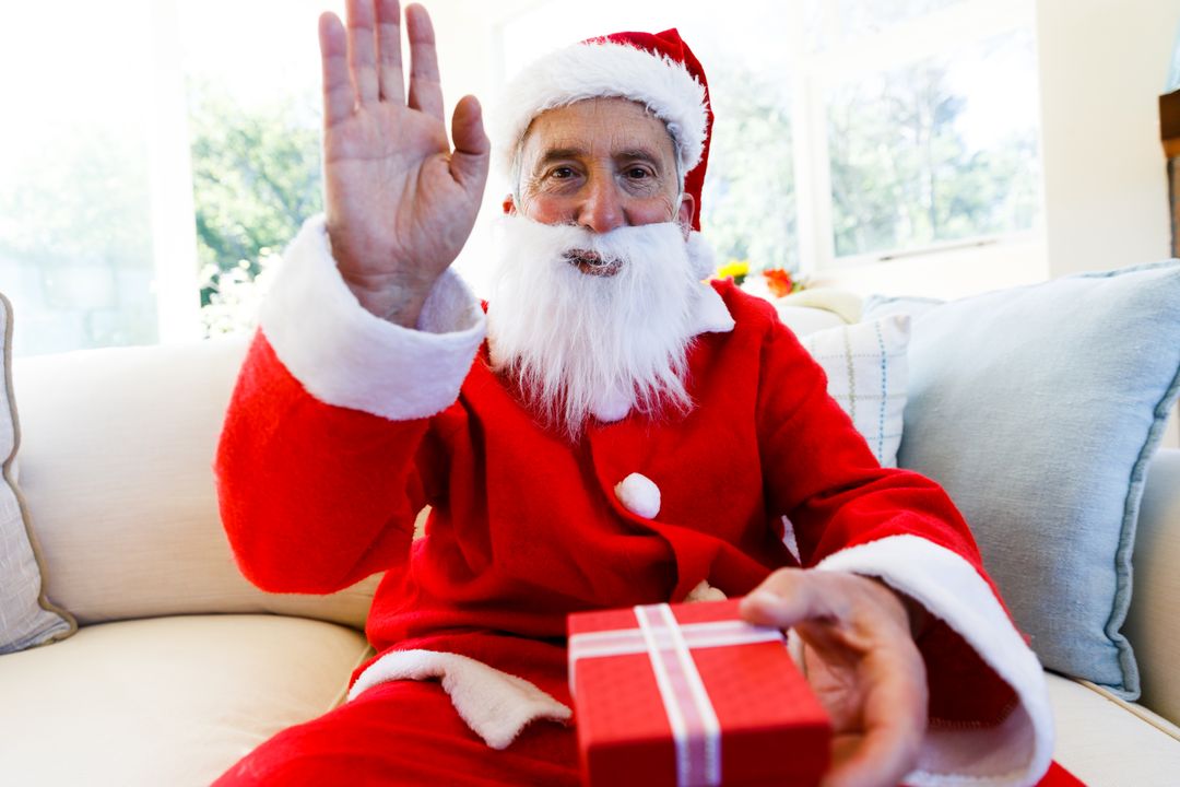 Elderly Man in Santa Costume Offering Christmas Gift - Free Images, Stock Photos and Pictures on Pikwizard.com
