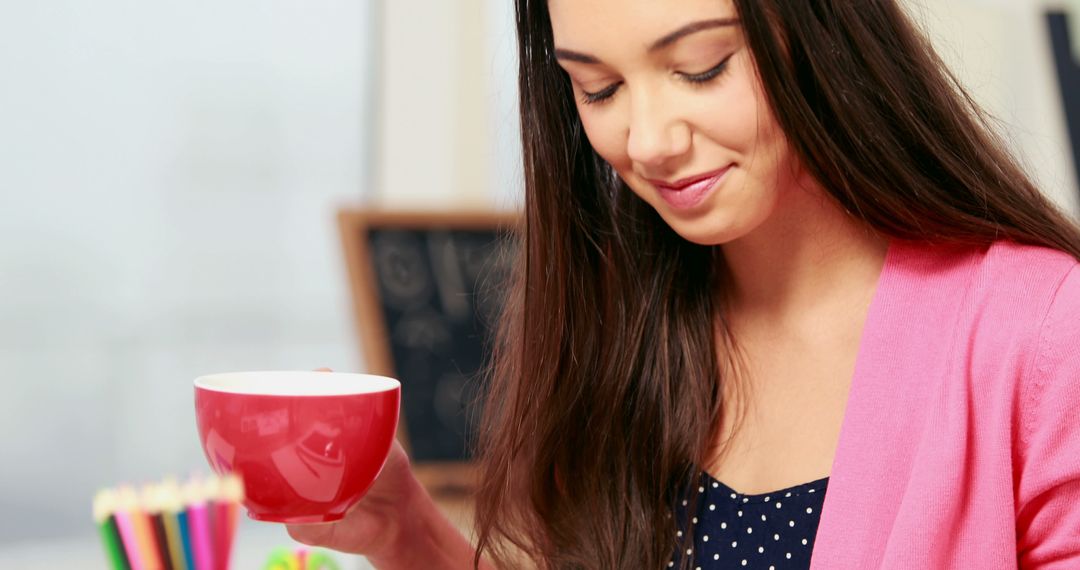 Young Woman Holding Cup Smiling While Enjoying Her Drink - Free Images, Stock Photos and Pictures on Pikwizard.com